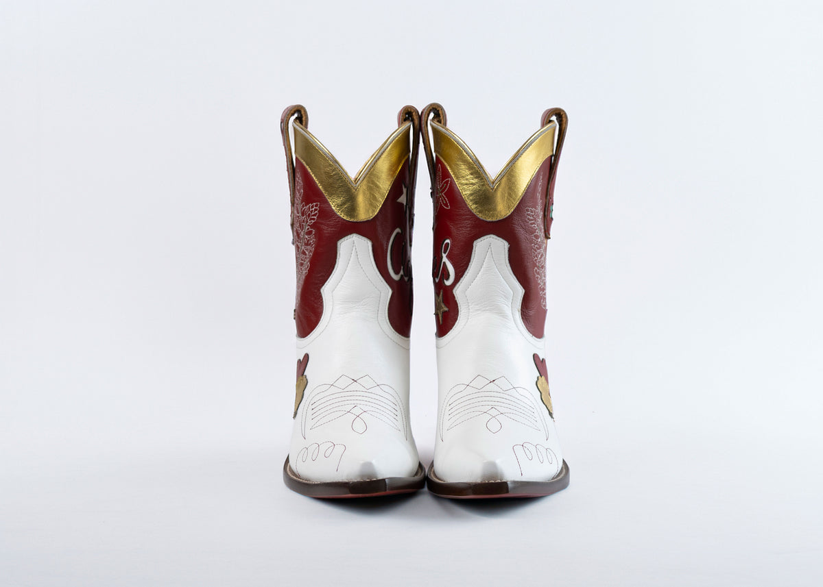Pair of Texas A&M cowboy boots with gold accents on a light gray background